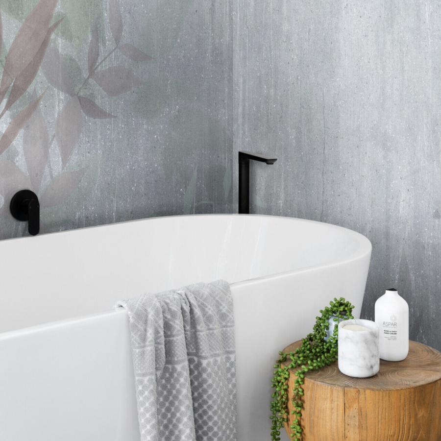 Moor Violet Tapete in einer Badezimmerumgebung mit grauer Wandstruktur, schwarzer Armatur, weißer Badewanne, Holz-Tischplatte, grünem Pflanzenakzent