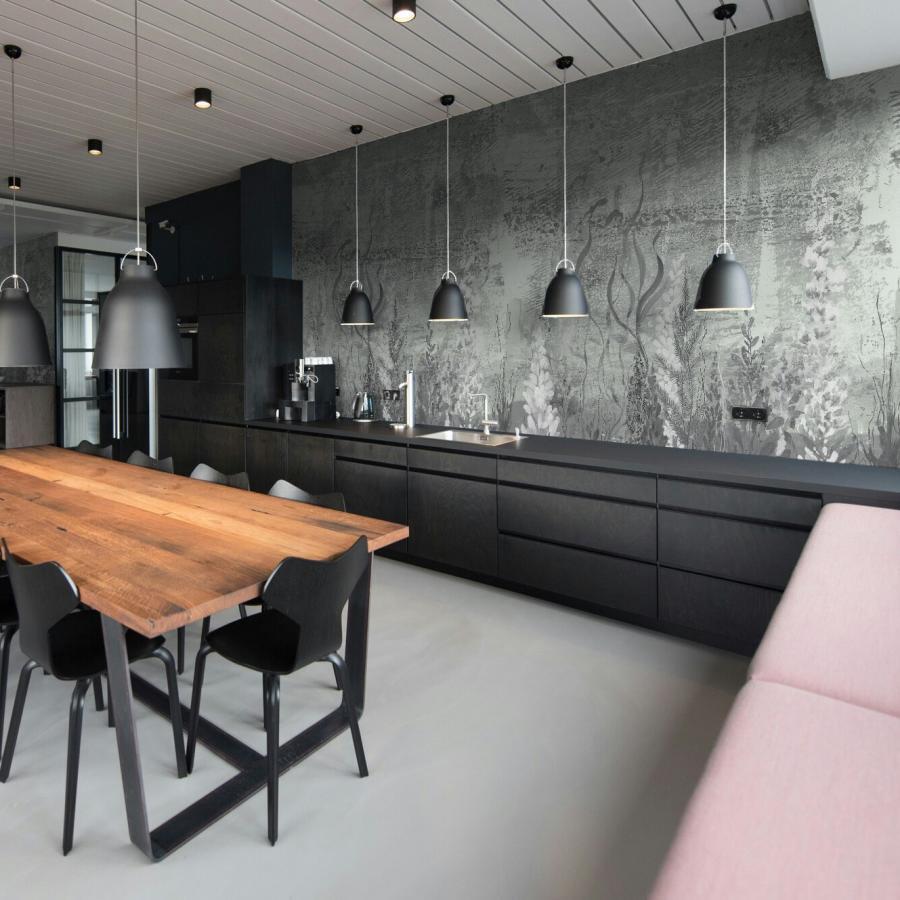 Weed-Sage Interieur: Dunkle Küchenkombination mit Holz-Tisch, schwarzen Stühlen und grauer, floraler Tapete, Beleuchtungshänge über der Arbeitszeile
