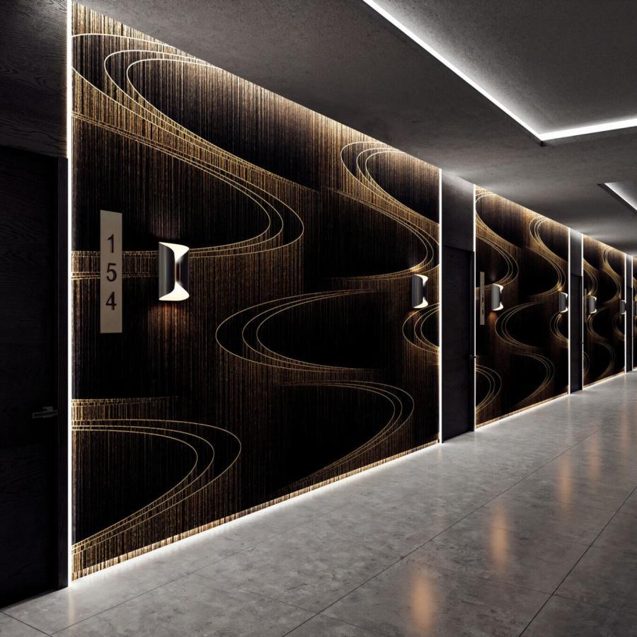 Waves Gold Wanddesign von k'moor walldesign zeigt dunkle Wandpaneele mit geschwungenen goldenen Linien, ergänzt durch LED-Lichtkanten und Spiegelungen auf hellen Bodenfliesen im Flur.