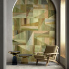 Discofox Wanddesign von k’moor mit geometrischer Musterung in Erdtonungen, einer gebogenen Wandöffnung, Lounge-Sessel und zwei Beistelltischen.