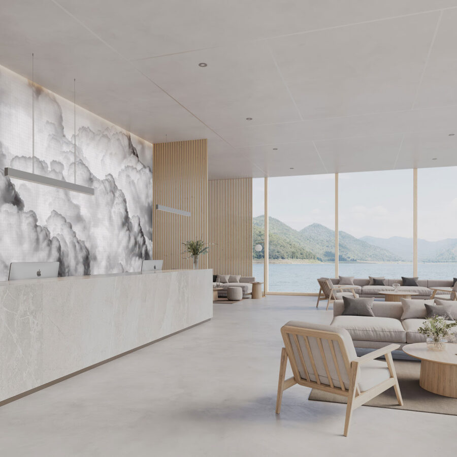 Heller Loungebereich mit Cloud Tiles Wandmotiv, Empfangstheke aus Marmor, moderne Holz- und Stoffmöbel, große Fenster mit Blick auf Berglandschaft