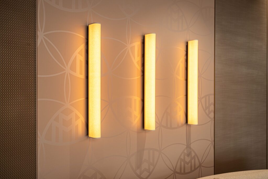 Tomislav Vukosav, Maybach Lounge Wanddesign von k'moor: warme, senkrechte Leuchten setzen Akzente an einer dekorativen Wand hinter Textiloberflächen