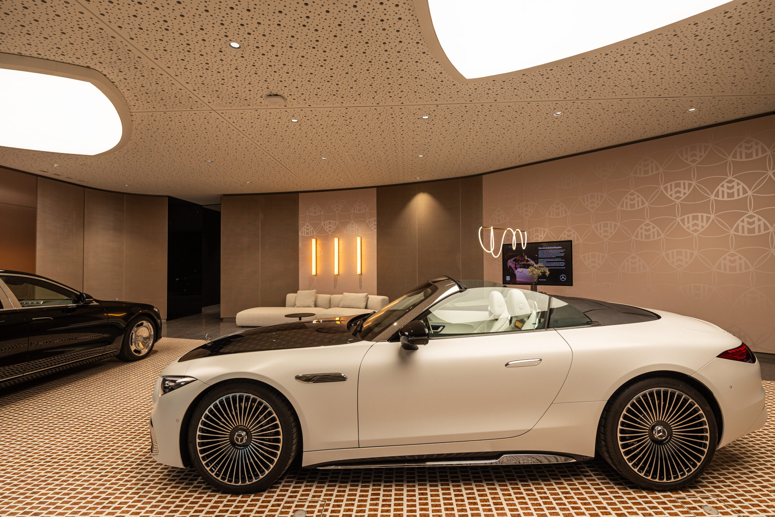 Tomislav Vukosav präsentiert ein weißes Cabriolet im großzügigen Showroom von tev store Köln; luxuriöser Innenraum, versenkbarem Verdeck und modernen Spiegeln